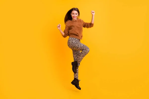 Фотографія повнометражного профілю фанк-леді, що стрибає високо радісно піднімає кулаки дивовижно виграшного одягу пухнастий светр штани взуття ізольовані жовтого кольору — стокове фото