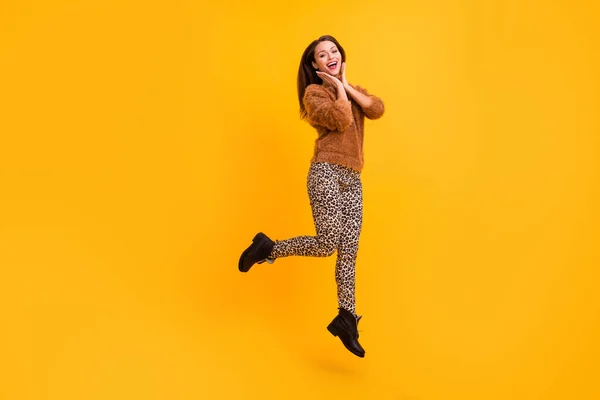 Full storlek profil foto av funky dam hoppa upp hög gott humör ungdom trend ser missbrukare shopper bära fluffig tröja leopard byxor stövlar isolerad gul färg bakgrund — Stockfoto