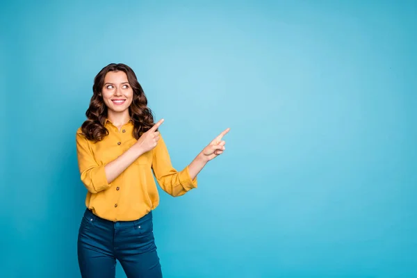 Photo of amazing business lady indicating finger empty space interested advising new product low discount price wear yellow shirt pants isolated blue color background — 图库照片
