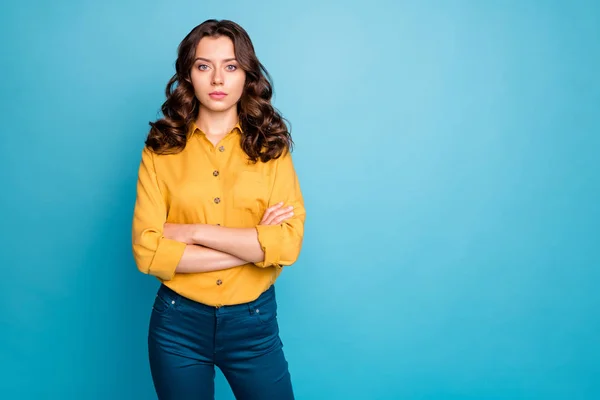 Photo of attractive curly business lady hold hands crossed seriously looking colleagues dislike coming work late wear yellow shirt trousers isolated blue color background — Stockfoto