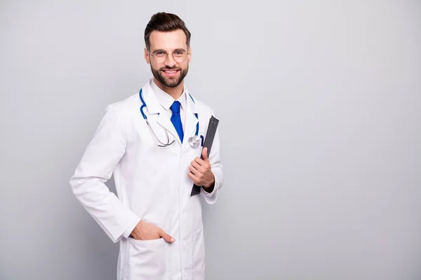 Πορτρέτο του ο ωραία ελκυστική χαρούμενη χαρούμενη γιατρός φορώντας φορμαρισμένα γιατρό κρατώντας στο χέρι πρόχειρο έγγραφο απομονώνονται σε ανοιχτό λευκό γκρι παστέλ χρώμα φόντο — Φωτογραφία Αρχείου