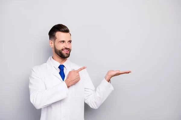 Portrait of his he nice attractive glad cheerful cheery confident doc holding on palm showing new novelty ad advert solution alternative isolated on light white gray pastel color background — Stock Photo, Image