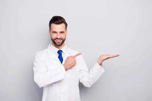 Portrait of his he nice attractive cheerful cheery confident doc holding on palm showing copy space new solution alternative isolated on light white gray pastel color background — 스톡 사진