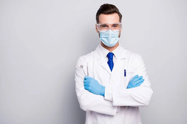 Close-up portrait of his he nice attractive cheerful experienced doc dentist holding in hands steel tools dental procedure center isolated on light white gray pastel color background — Stock Photo, Image