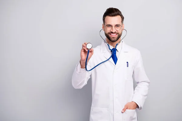 Portret van mooie aantrekkelijke voorzichtige vrolijke vrolijke bebaarde dokter luisteren uw ademhaling hartslag medicare eerste hulp hulp hulp geïsoleerd op licht wit grijs pastel kleur achtergrond — Stockfoto