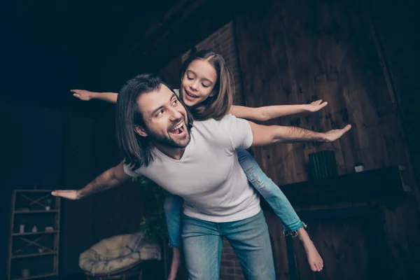 Foto de la señora enérgica poco divertido emocionado guapo papá llevar hija jugando juegos buen humor pasar tiempo libre juntos brazos extendidos como alas casa habitación interior — Foto de Stock