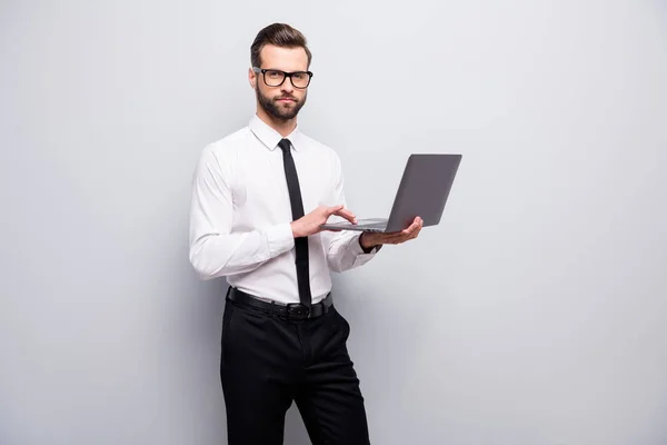 Strict skupione agent nieruchomości szef człowiek trzymać laptop używać nowoczesnych technologii pracy nad swoim projektem warsztaty nosić białą koszulę czarne spodnie odizolowane szary kolor tła — Zdjęcie stockowe