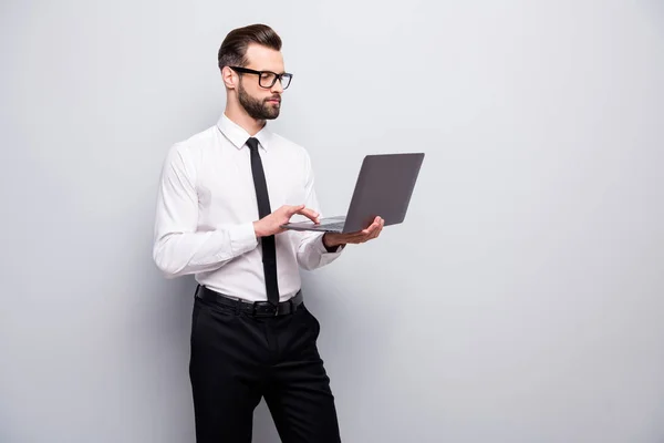 Portret pewny siebie fajny ekspert człowiek przedsiębiorca używać komputer czytać dokument zrobić projekt wygląd ekran nosić biały czarny strój odizolowany na szarym tle kolor — Zdjęcie stockowe