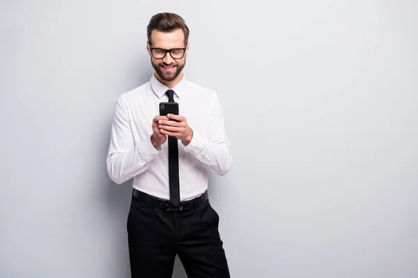 Portrait of positive cheerful clerk man use his smartphone have online conversation with colleagues partnership wear black white outfit isolated over grey color background — 스톡 사진