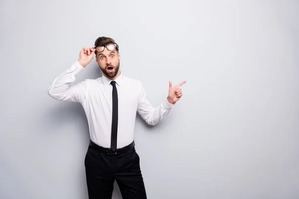 Foto de loco hombre de negocios indican dedo espacio vacío que muestra a los clientes novedad fresca boca abierta quitándose especificaciones usar pantalones de camisa corbata aislado color gris fondo —  Fotos de Stock