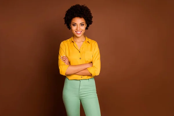 Photo of stunning business dark skin curly lady looking colleagues good mood arms crossed friendly smiling wear yellow shirt green pants isolated brown color background — Stock Photo, Image
