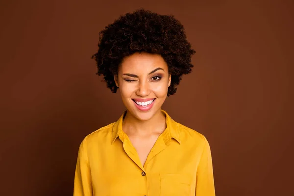 Closeup photo of funny beautiful pretty dark skin wavy lady positive good mood flirty blinking one eye wear yellow shirt blouse isolated brown color background — Stock Photo, Image