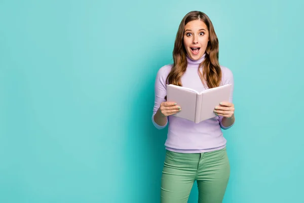 Foto von schönen aufgeregt wellige Dame halten Planer Tagebuch Buch offenen Mund lesen Wissenschaft Fakten nicht glauben Augen tragen Flieder Pullover grüne Hose isoliert Krickente Pastellfarbe Hintergrund — Stockfoto