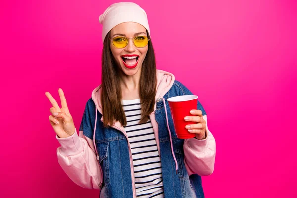 Retrato de cerca de agradable atractiva hermosa chica alegre alegre bonita sosteniendo en la mano sabrosa taza de café delicioso que muestra v-signo aislado en brillante brillo vivo vibrante rosa fucsia color fondo —  Fotos de Stock