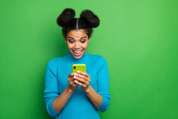 Foto de funky hermosa piel oscura dama sostener teléfono manos boca abierta comprobar comentarios seguidores post repost desgaste azul cuello alto jersey aislado color verde fondo — Foto de Stock