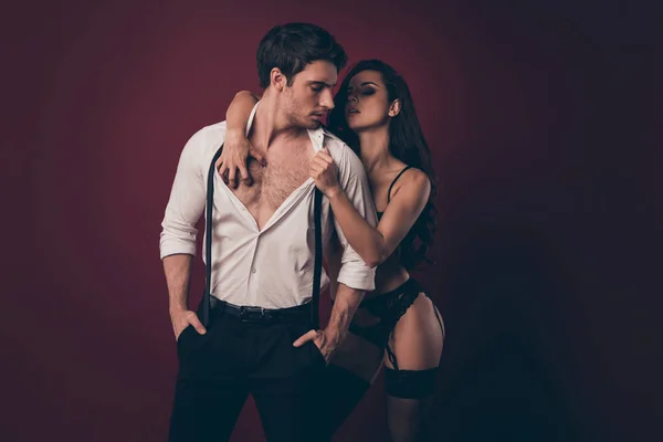 Photo of two hot people macho husband stand quiet wait bikini mistress wife undress his suit shirt tie scratch his nude torso submission role play isolated maroon color background — ストック写真