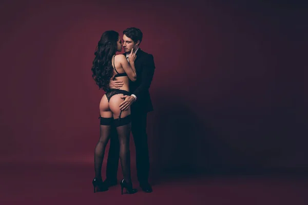 Full size photo of horny two people husband return home work nude shapes bum black bikini wife meets macho undress his suit kiss desire isolated burgundy color background