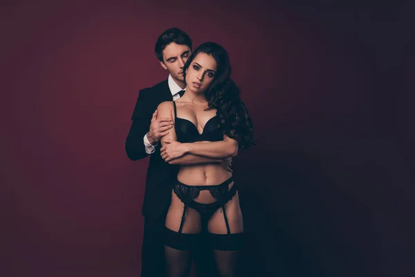 Photo of tender horny two people husband black suit wife sexy boudoir ideal body stand close tempting desire dream whisper secret wishes ear isolated burgundy color background — Stok fotoğraf