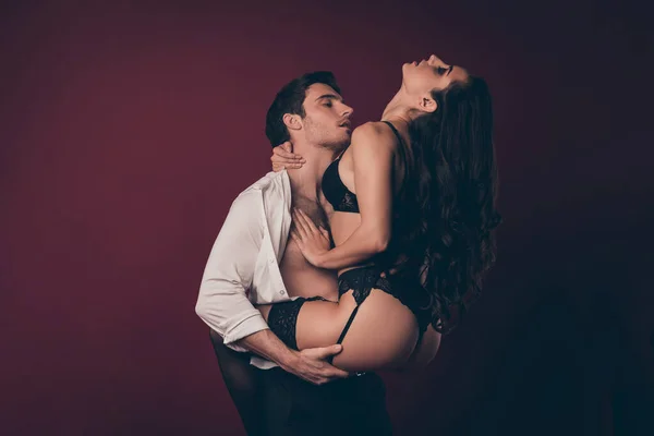 Profile photo of tender horny two people handsome husband hold hands hips raise nude hot black bikini wife tempting virile body strong arms isolated maroon color background — 스톡 사진