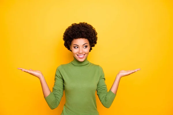 Photo of cheerful positive curly wavy stylish trendy girl holding two objects with hands smiling toothily in green turtleneck isolated vivid color background — 图库照片