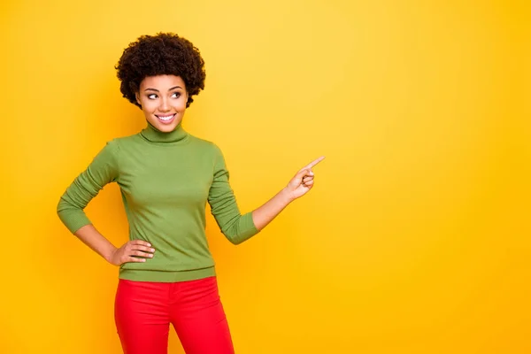 Photo of cheerful positive cute pretty sweet girl pointing into empty space for you to follow social media account isolated in red pants vivid color background — 图库照片