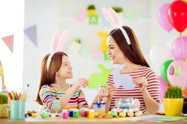 Close-up portrait of nice attractive lovely creative cheerful cheery girls small little daughter wearing bunny ears having fun creating making handicraft in white light interior room house — Stockfoto