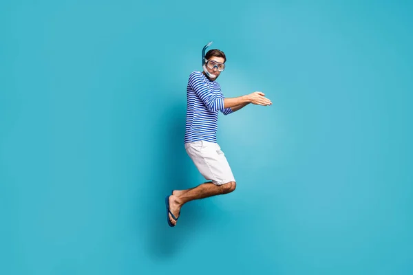 Full length profile photo of funky crazy guy tourist jump high swimming water mask tube diving wear striped sailor shirt vest shorts flip flops isolated blue color background — 图库照片