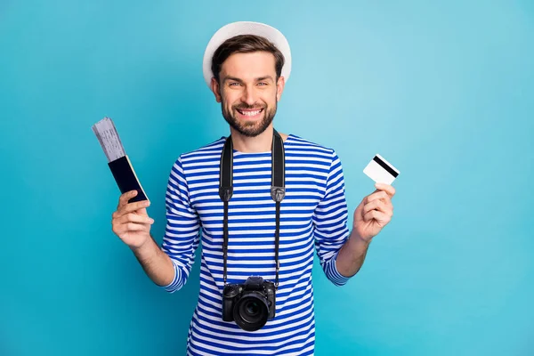 Photo of attractive guy photographer hold professional digital camera traveler buy tickets with help of credit card wear striped sailor shirt vest cap isolated blue color background — 스톡 사진