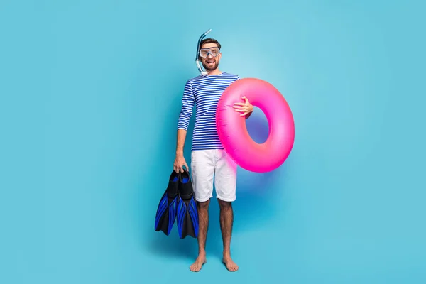 Full body foto di divertente eccitato ragazzo turista nuotatore tenere maschera subacquea respirazione tubo pinne rosa salvagente usura a righe marinaio camicia pantaloncini isolato colore blu sfondo — Foto Stock