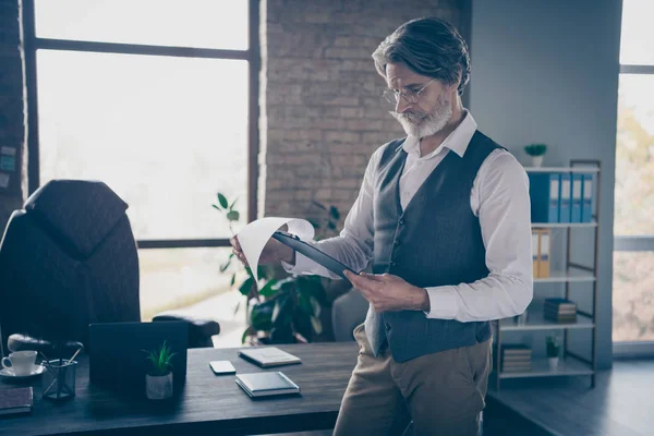 Perfil foto lateral focada mentalmente inteligente velho advogado ler colar relatório segure prancheta analisar start-up estratégia desgaste formalwear branco elegante calças de camisa na moda no local de trabalho moderno — Fotografia de Stock