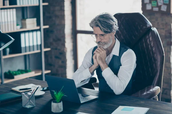 Concentrato mentalità pensieroso agente barbuto società collare rappresentativo vecchio seduto lavoro tavolo sul computer portatile leggere i colleghi riportano indossare gilet nella moderna postazione di lavoro — Foto Stock