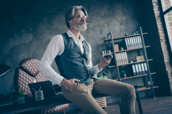 Çekici, şık, zarif, zarif, ciddi, gri saçlı adam uzman portresi modern tuğla sanayi tipi iç mekan istasyonunda içki içiyor. — Stok fotoğraf