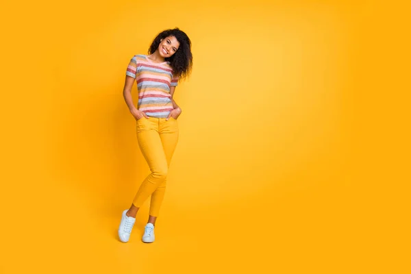 Повнометражний вигляд на тіло красивої жінки красива весела хвиляста дівчина в смугастій футболці, яка позує ізольовано на яскравому яскравому сяйві яскраво-жовтого кольору фону — стокове фото