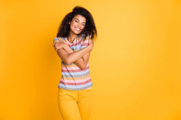 Portrait of her she nice lovely sweet gentle dreamy cheerful cheery wavy-haired girl wearing striped tshirt hugging herself isolated over bright vivid shine vibrant yellow color background — Stock Photo, Image