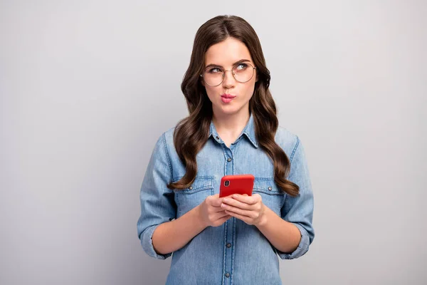 Foto van mooie zakenvrouw browsen telefoon diep denken opzoeken lege ruimte schrijven creatieve jeugd thema post slijtage specs casual jeans denim shirt geïsoleerde grijze kleur achtergrond — Stockfoto