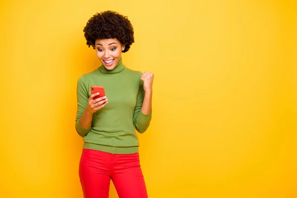 Φωτογραφία του χαρούμενα ενθουσιασμένος θεραπεία αρκετά ωραίο περιχαρείς κορίτσι ανάγνωση νέες κοινοποιήσεις στο τηλέφωνό της σε κόκκινο παντελόνι χαμογελώντας οδοντικά απομονώνονται πάνω από κίτρινο ζωντανό χρώμα φόντο — Φωτογραφία Αρχείου