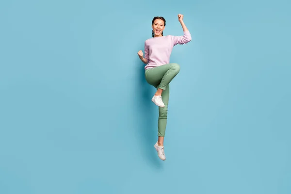 Hooray. Full body photo of funny lady jumping high good mood win sportive competition championship wear casual pink pullover green trousers shoes isolated blue color background — 图库照片