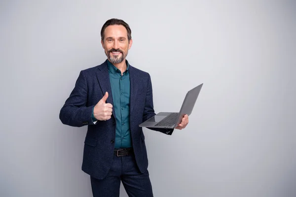 Photo of handsome business man holding notebook friendly raising thumb finger up approving good device quality formalwear blazer shirt pants blue suit isolated grey color background