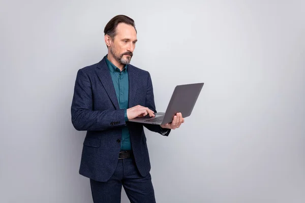 Photo of attractive focused business man holding notebook reading colleagues report email writing answer formalwear blazer shirt pants blue suit isolated grey color background