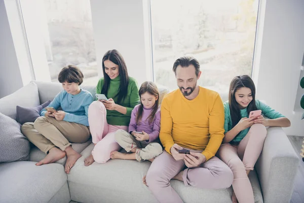 Retrato de agradable atractivo grande alegre alegre alegre familia pre-adolescente niños pasar tiempo libre sentado en el sofá utilizando el dispositivo digital en acogedora casa de estilo interior blanco luz acogedora sala de estar —  Fotos de Stock