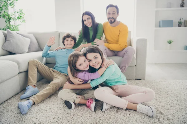 Retrato de agradável atraente adorável adorável perfeito feliz grande cheio alegre família pré-adolescente crianças mãe pai passar tempo abraçando no aconchegante confortável luz branco interior estilo casa sala de estar — Fotografia de Stock