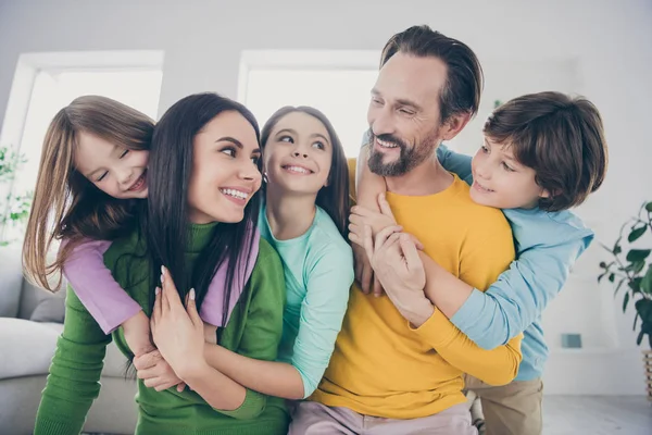 Close-up portrait of nice attractive lovely affectionate adorable friendly careful cheerful cheery family three pre-teen kids mom dad embracing having fun at light white interior style house — Stock Photo, Image