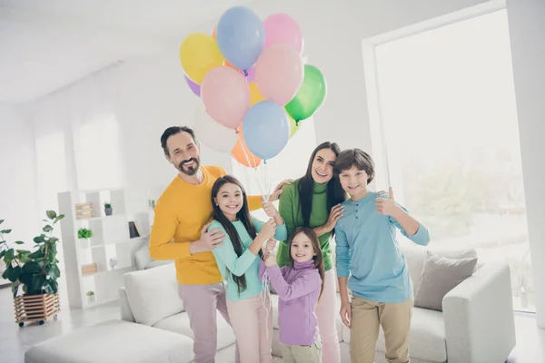 Soñar comodidad acogedora armonía personas familia celebrar globos de aire disfrutar de evento festivo tres niños preadolescentes colegial mostrar pulgar hacia arriba signo aprobar buen evento stand sofá en la casa sala de estar —  Fotos de Stock