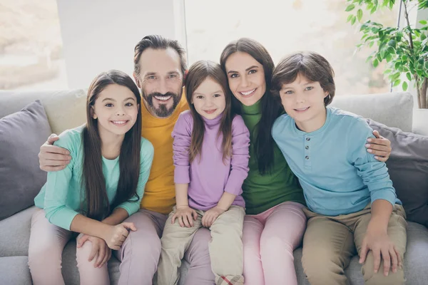 Encantador completo familia grande sentarse sofá disfrutar de pasar vacaciones de tiempo libre juntos papá papá mamá mamá abrazo su preadolescente colegial niña pequeña en casa sala de estar — Foto de Stock