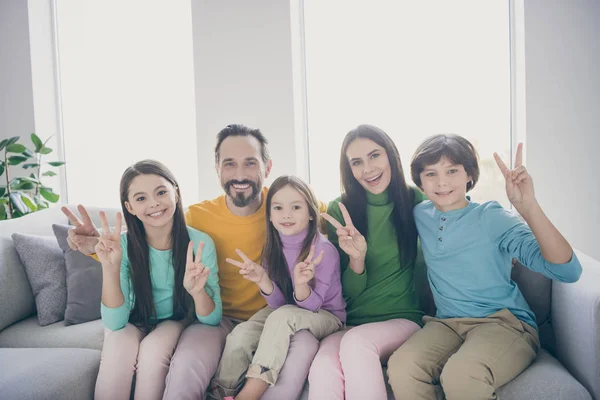 Positiv fröhlich Familie fünf Personen Papa Mama sitzen gemütliche Couch drei Kind Preteen kleiner Junge Mädchen machen V-Zeichen genießen Harmonie im Haus Wohnzimmer — Stockfoto