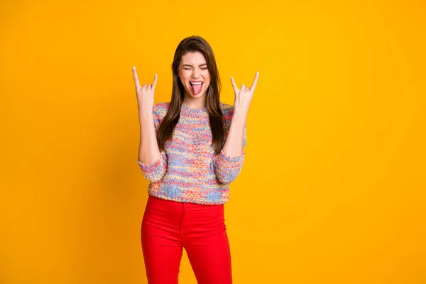 Sí, genial. Loco excitado alegre adolescente disfrutar fin de semana concierto cerrar los ojos regocijarse hacer cuernos símbolo mostrar lengua fuera usar pantalones rojos suéter aislado brillo color fondo —  Fotos de Stock