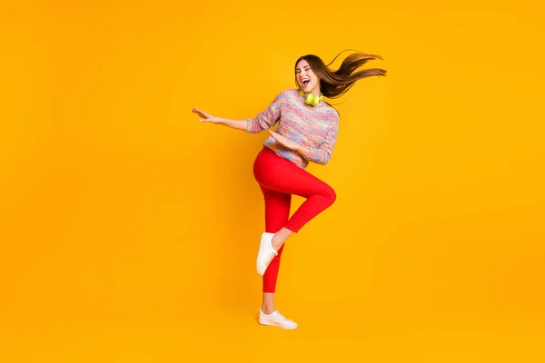 Pełna długość zdjęcie pozytywne wesoły dj dziewczyna słuchać melodia muzyka playlista słuchawki taniec tancerka na disco podłoga impreza nosić czerwone spodnie sweter gumowe buty odizolowany żółty kolor tło — Zdjęcie stockowe