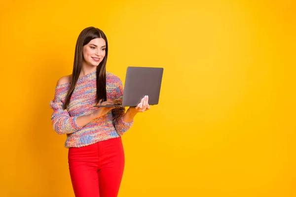 Portré pozitív vidám lány munka a számítógépén videó filmek csevegés online közösségi média barátok viselnek piros őszi tavaszi nadrág nadrág elszigetelt felett élénk színű háttér — Stock Fotó