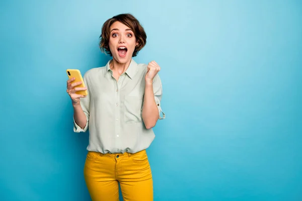 美しい女性の写真を保持電話オープン口を購入するスマートフォン低販売ショッピング価格を着用カジュアル緑のシャツ黄色パンツ隔離された青の色の背景 — ストック写真