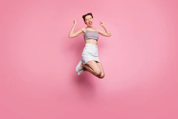 Foto de cuerpo completo de la chica positiva encantada salto de lotería tienen descuentos noticias grito sí sí levantar los puños se siente regocijo emociones usar ropa de estilo casual aislado color rosa fondo — Foto de Stock